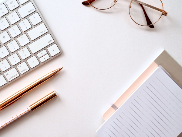 notepad glases and keybord on desk